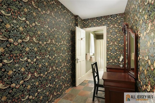 241 E Chestnut Ave, Metuchen, NJ 08840 - unfurnished dining area with wallpapered walls and dark stone finish flooring