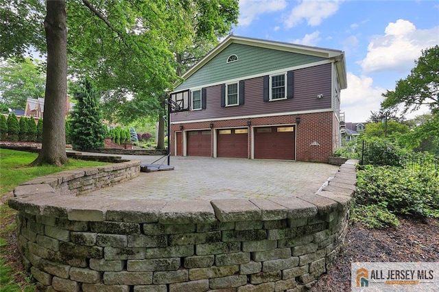 241 E Chestnut Ave, Metuchen, NJ 08840 - view of front of home featuring an attached garage, driveway, and brick siding