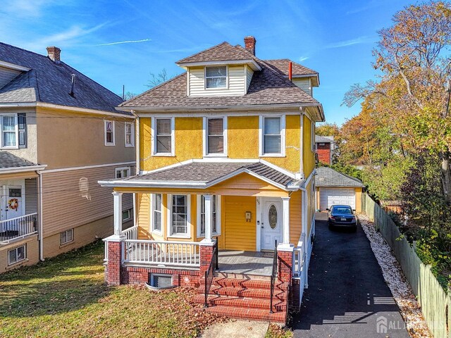 view of front of house with an outbuilding, central AC unit, a porch, and a garage