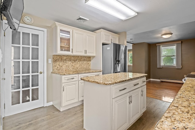 15 Cutter Ave, Fords, NJ 08863 - kitchen featuring stainless steel refrigerator with ice dispenser, a baseboard radiator, light wood-style floors, light stone countertops, and glass insert cabinets