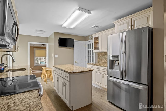 15 Cutter Ave, Fords, NJ 08863 - kitchen with appliances with stainless steel finishes, a sink, cream cabinets, decorative backsplash, and a center island