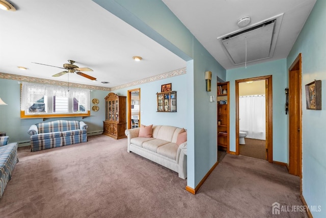 living area featuring ceiling fan, baseboards, attic access, carpet floors, and baseboard heating