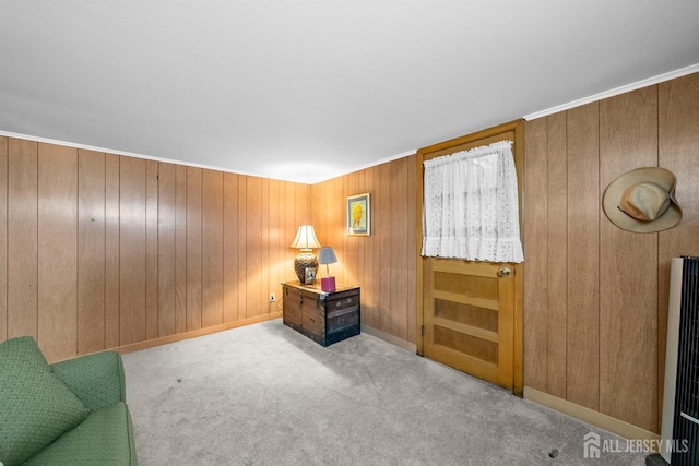 living area with wood walls, baseboards, and carpet