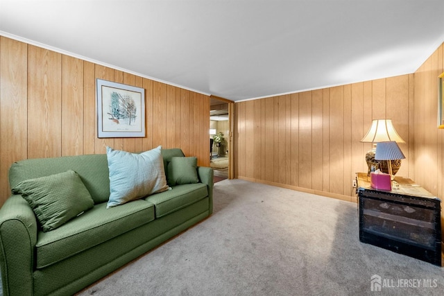 carpeted living room with wooden walls and baseboards