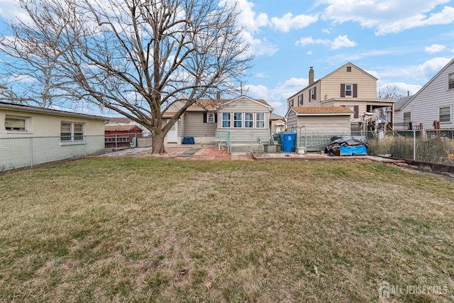 back of property with a patio area, a lawn, and a fenced backyard