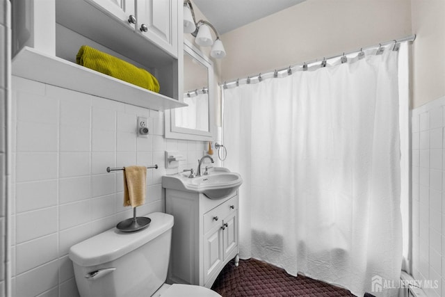 bathroom with curtained shower, tile walls, vanity, and toilet