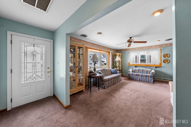 foyer entrance featuring visible vents, carpet flooring, and a baseboard heating unit