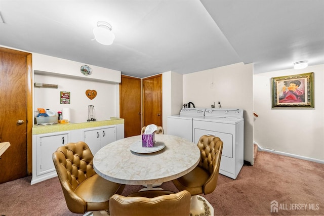 dining room featuring light carpet, washer and dryer, and baseboards