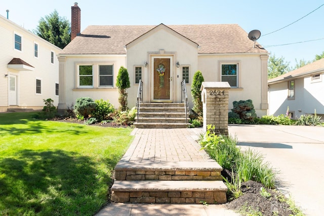 2624 Tremley Point Rd, Linden, NJ 07036 - view of front of property with roof with shingles, stucco siding, a front lawn, and a chimney