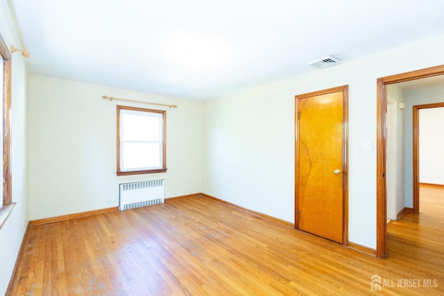 2624 Tremley Point Rd, Linden, NJ 07036 - empty room with radiator heating unit, light wood-style flooring, and baseboards