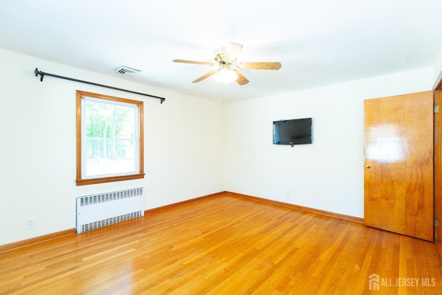 2624 Tremley Point Rd, Linden, NJ 07036 - spare room with radiator heating unit, ceiling fan, light wood-type flooring, and baseboards
