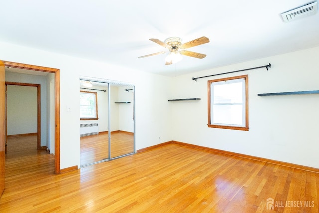 2624 Tremley Point Rd, Linden, NJ 07036 - unfurnished bedroom featuring radiator, a closet, light wood finished floors, baseboards, and ceiling fan