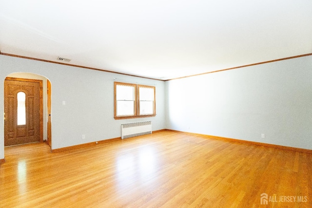 2624 Tremley Point Rd, Linden, NJ 07036 - unfurnished room featuring radiator heating unit, arched walkways, light wood-style floors, and crown molding