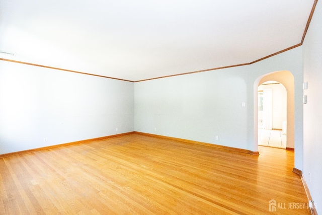 2624 Tremley Point Rd, Linden, NJ 07036 - unfurnished room featuring crown molding, arched walkways, light wood-type flooring, and baseboards