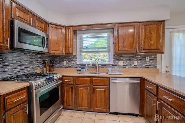 55 Cambridge Way, West Windsor, NJ 08550 - kitchen featuring appliances with stainless steel finishes, a sink, light tile patterned floors, and brown cabinets
