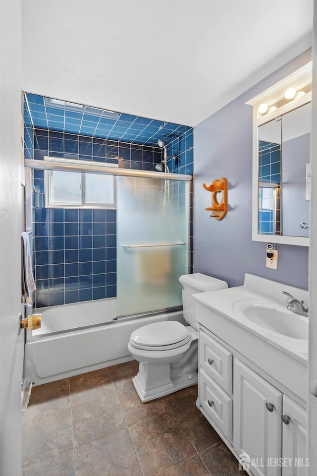 bathroom featuring vanity, toilet, and combined bath / shower with glass door