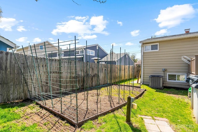 view of yard with central AC unit and a garden