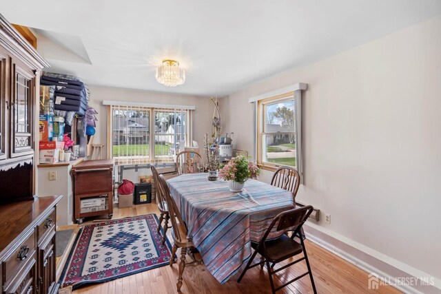 69 Claridge Pl, Colonia, NJ 07067 - dining area with a chandelier, healthy amount of natural light, wood finished floors, and baseboards