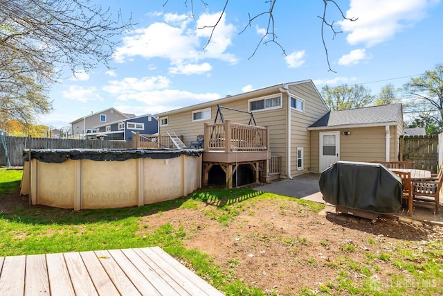 rear view of property featuring a deck and fence