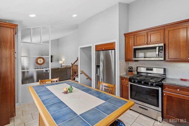 kitchen featuring appliances with stainless steel finishes, tasteful backsplash, light tile patterned flooring, tile countertops, and recessed lighting