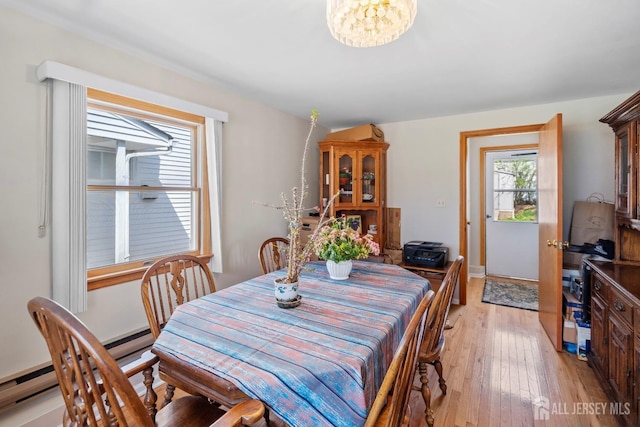 dining room featuring light wood-type flooring and a chandelier