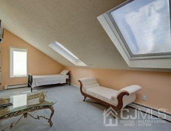 interior space featuring a textured ceiling, lofted ceiling with skylight, and carpet floors