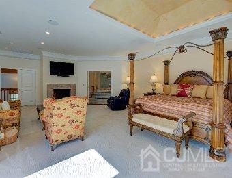 bedroom with a fireplace and crown molding