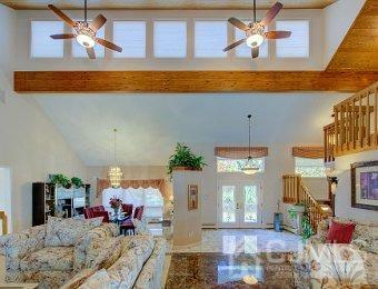 living room featuring a towering ceiling, french doors, ceiling fan, and beam ceiling