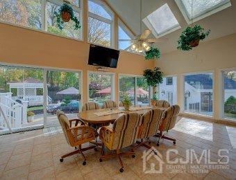 tiled dining room featuring a towering ceiling, a skylight, and a healthy amount of sunlight