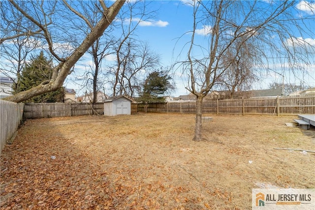 view of yard with a shed, a fenced backyard, and an outdoor structure