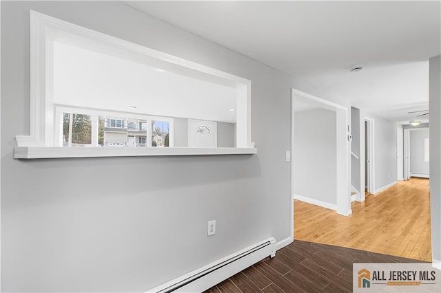 interior space featuring baseboards, a baseboard radiator, a baseboard heating unit, and wood finished floors