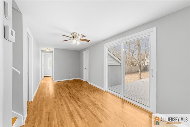 interior space with light wood-style flooring, baseboards, and ceiling fan