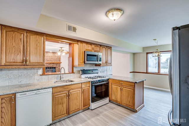 86 Bunker Hill Rd, Lawrence, NJ 08648 - kitchen featuring stainless steel appliances, a peninsula, light wood-style flooring, and brown cabinetry