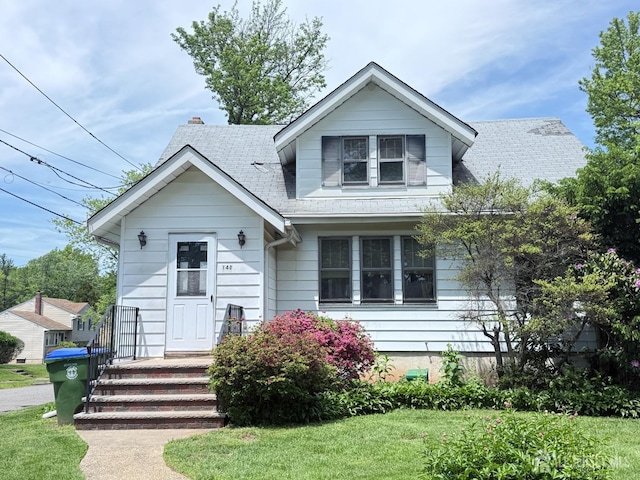bungalow-style house with roof with shingles and a front yard