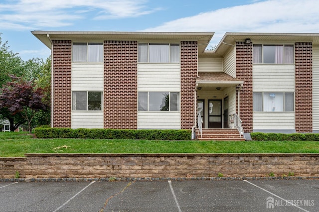 101 Mandon Ct Unit 4, South Brunswick, NJ 08540 - view of front of house featuring uncovered parking, a front yard, and brick siding