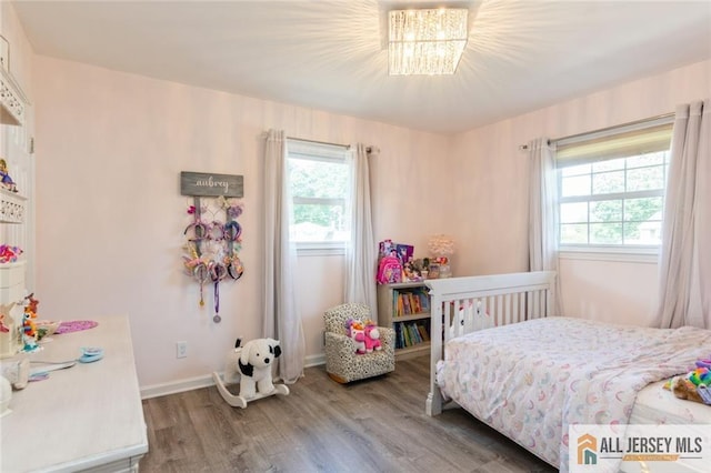 1516 N Indian Pl, North Brunswick, NJ 08902 - bedroom featuring multiple windows, wood finished floors, and a chandelier