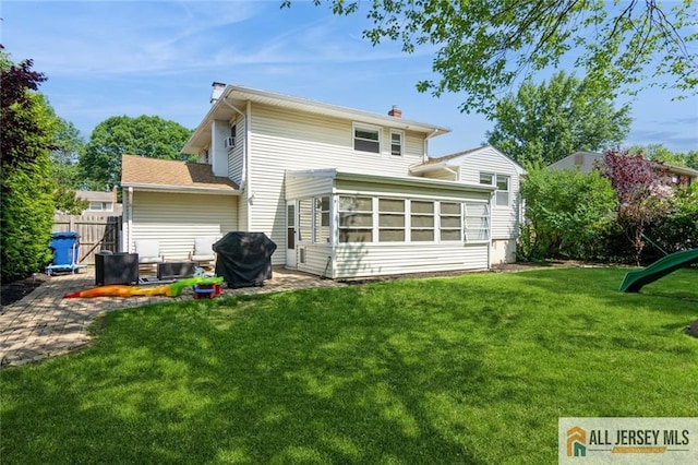 1516 N Indian Pl, North Brunswick, NJ 08902 - rear view of house with a chimney and a sunroom