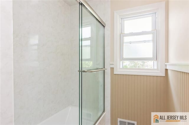 1516 N Indian Pl, North Brunswick, NJ 08902 - bathroom featuring wainscoting, plenty of natural light, and bath / shower combo with glass door
