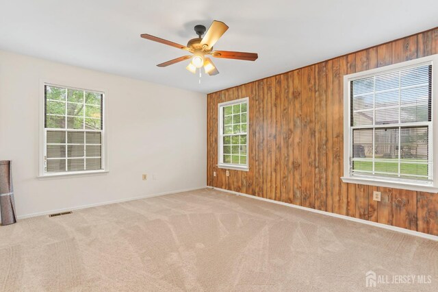 123 Concordia Cir Unit G, Monroe, NJ 08831 - carpeted spare room featuring baseboards, wooden walls, and a ceiling fan