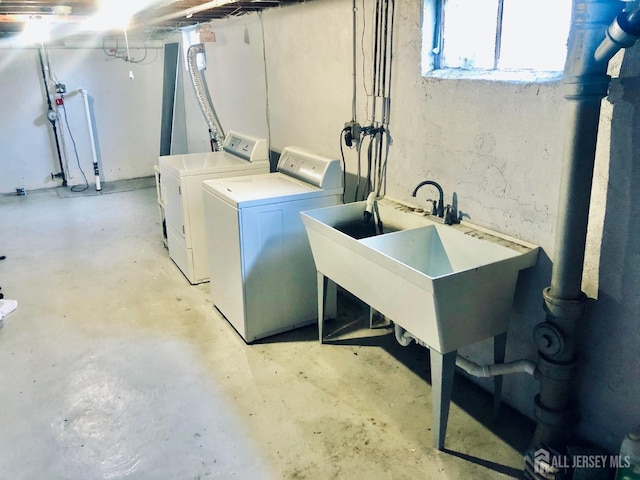 washroom featuring a sink, laundry area, and independent washer and dryer