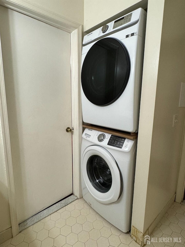 clothes washing area featuring stacked washer and clothes dryer