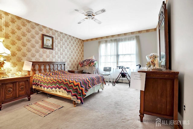 carpeted bedroom featuring ceiling fan and wallpapered walls