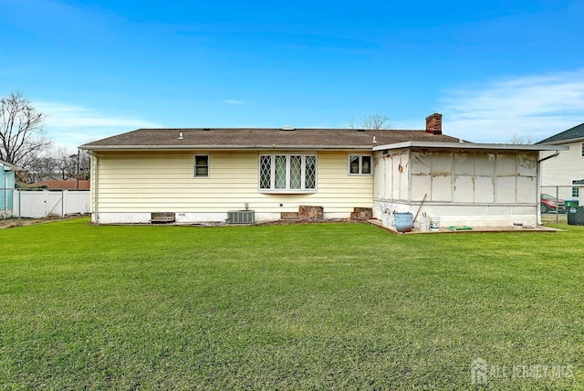 back of house featuring crawl space, central AC, fence, and a lawn