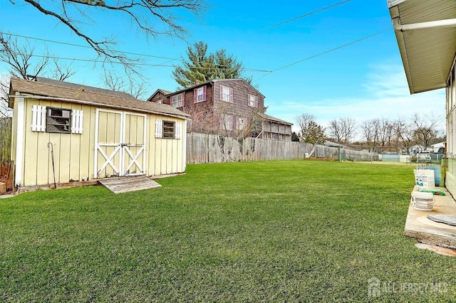 view of yard featuring a storage shed, an outdoor structure, and a fenced backyard