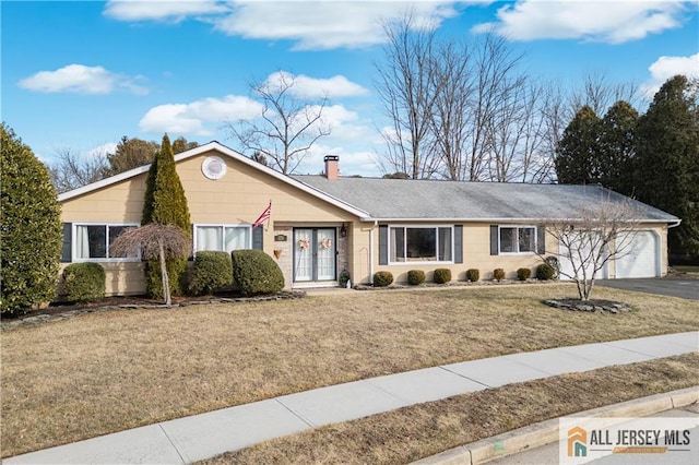 8 N Rhoda St, Monroe, NJ 08831 - view of front facade with french doors, an attached garage, a chimney, asphalt driveway, and a front yard