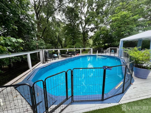 520 Albermarle St, Rahway, NJ 07065 - view of swimming pool featuring a gazebo, view of wooded area, and a wooden deck
