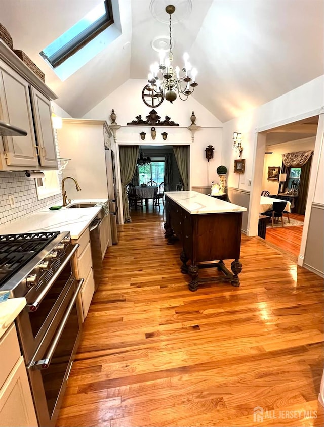 520 Albermarle St, Rahway, NJ 07065 - kitchen featuring stainless steel appliances, a skylight, vaulted ceiling, a chandelier, and light wood finished floors