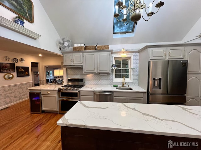 520 Albermarle St, Rahway, NJ 07065 - kitchen featuring stainless steel appliances, wine cooler, gray cabinetry, light wood-style floors, and high vaulted ceiling