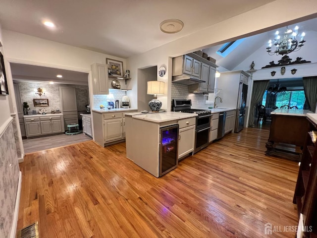 520 Albermarle St, Rahway, NJ 07065 - kitchen with appliances with stainless steel finishes, a chandelier, under cabinet range hood, light wood-type flooring, and vaulted ceiling