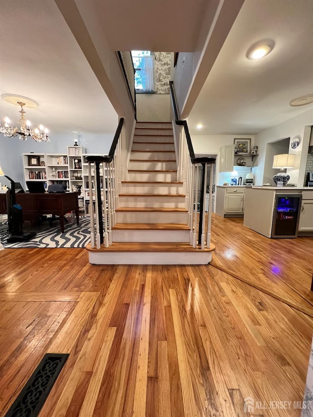 520 Albermarle St, Rahway, NJ 07065 - staircase featuring wood finished floors, a chandelier, and wine cooler